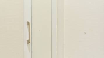 A white door with a handle, a visible lock, and a small hole in the door.
