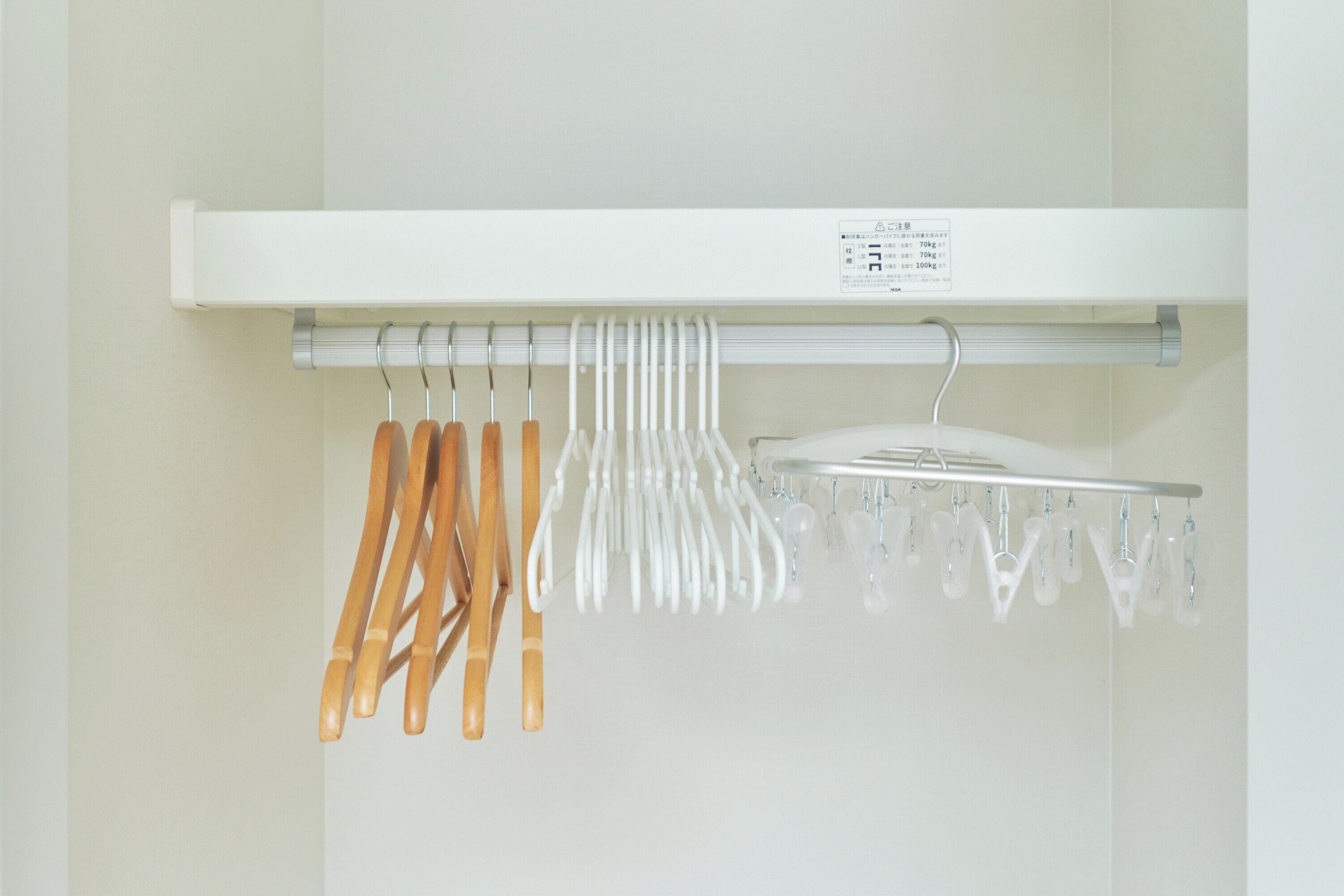 A white shelf with a label, holding various kitchen utensils and a white appliance.
