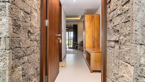 Un pasillo con paredes de piedra, una puerta de madera y un armario de madera.
