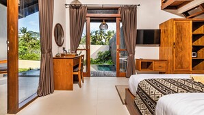 Un dormitorio con una cama grande, un escritorio y vistas a una piscina.