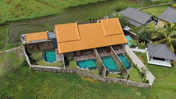 A large house with a tiled roof, multiple swimming pools, and a surrounding garden. - Sabuh Mas Villa Ubud By Aswanaya (Tegallalang)