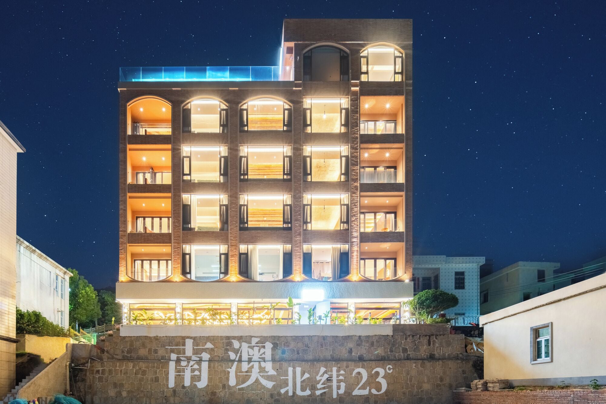A multi-story hotel with illuminated windows and a stone facade.