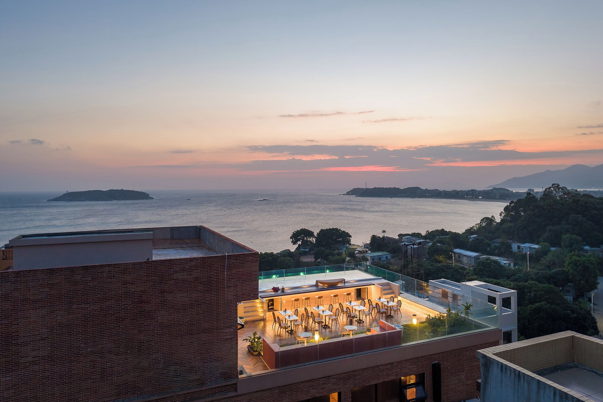 A rooftop terrace with outdoor seating and a view of the sea.