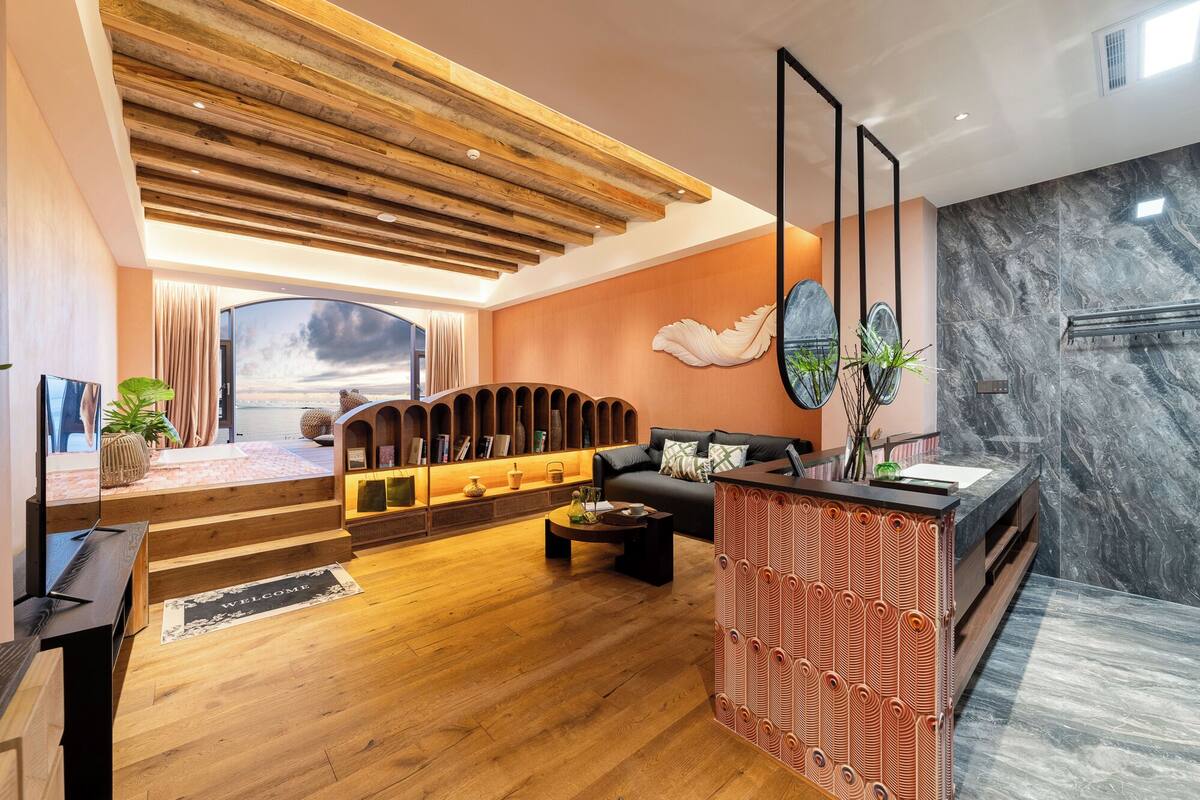 A modern living room with a wooden ceiling, a sofa, a coffee table, and a reception desk.