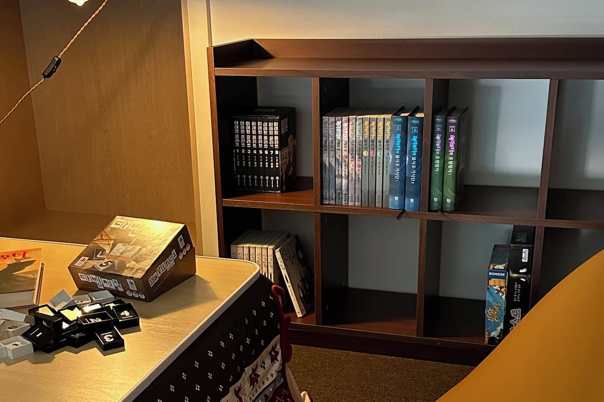 A room with a desk, a bookshelf, and a patterned rug.