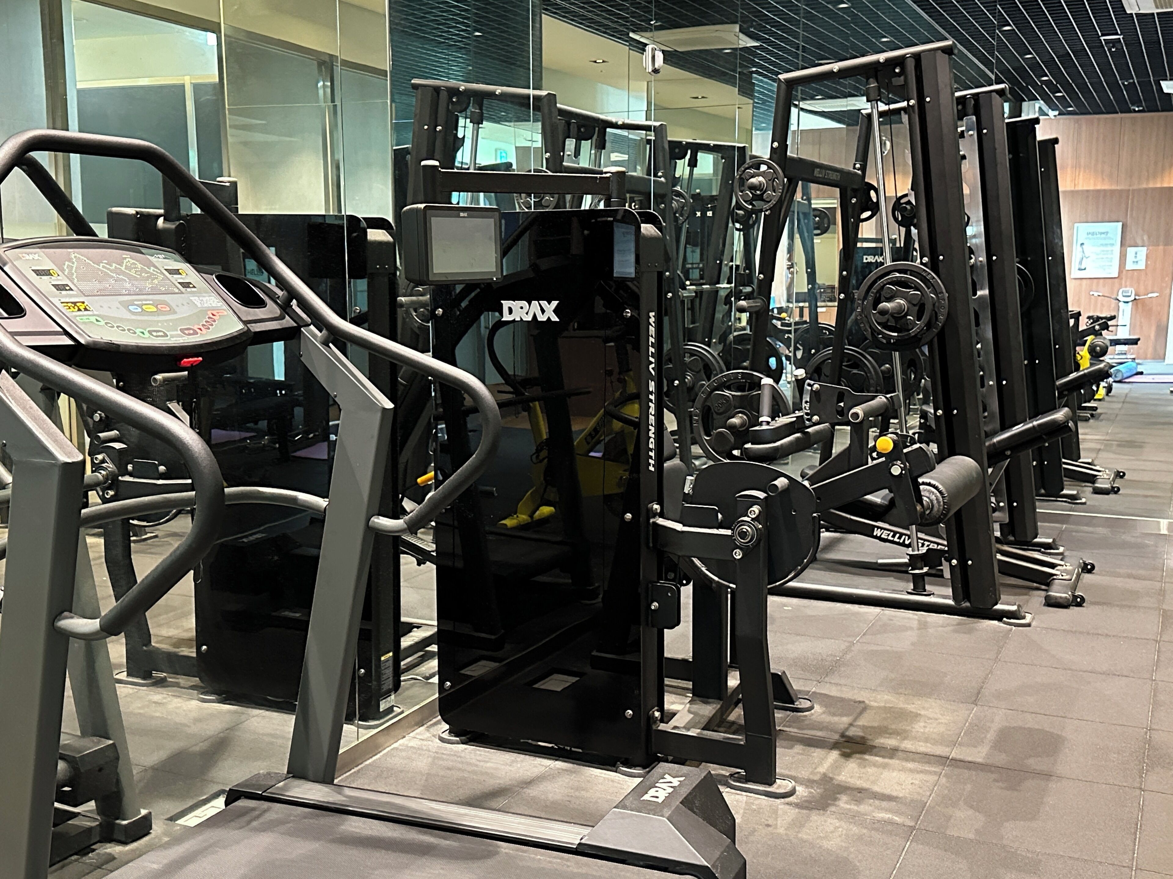 A gym with various exercise machines, including treadmills and weightlifting equipment.