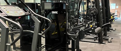 A gym with various exercise machines, including treadmills and weightlifting equipment.