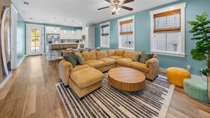 A spacious living area with a large L-shaped sectional sofa, a round coffee table, and a ceiling fan. - August Sale - Private Pool –Gameroom - blk 2 beach (Panama City)