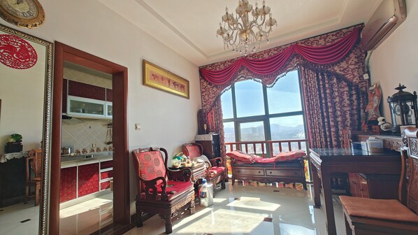A traditional room with a large window, a chandelier, and a wooden cabinet. - Mommy's home with breadfast and more (Qingdao)