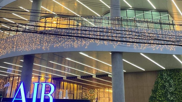 Ein mehrstöckiges Gebäude mit einem gut sichtbaren 'AIR'-Schild am Sockel, das ein modernes architektonisches Design mit geschwungenen Linien und großen Fenstern aufweist.
