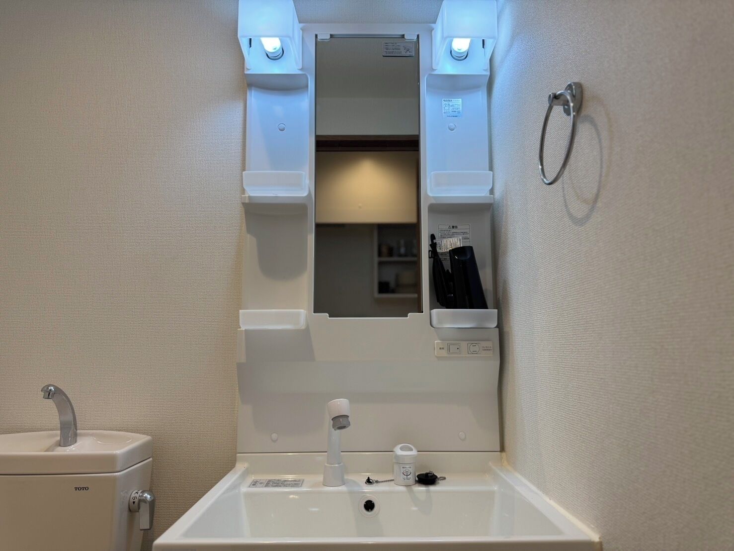 Un bagno con lavandino, specchio e portasciugamani.