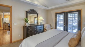 A bedroom with a large bed, a dresser, a mirror, and a chair. - Mountain Views, Pet Friendly, New Hot Tub, Fenced Yard, Near Trails! (Pagosa Springs)