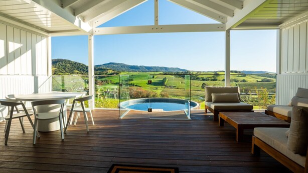 A covered outdoor deck with a pool, seating, and a table. - Estate House Villas - Crooked River Estate (Gerringong)