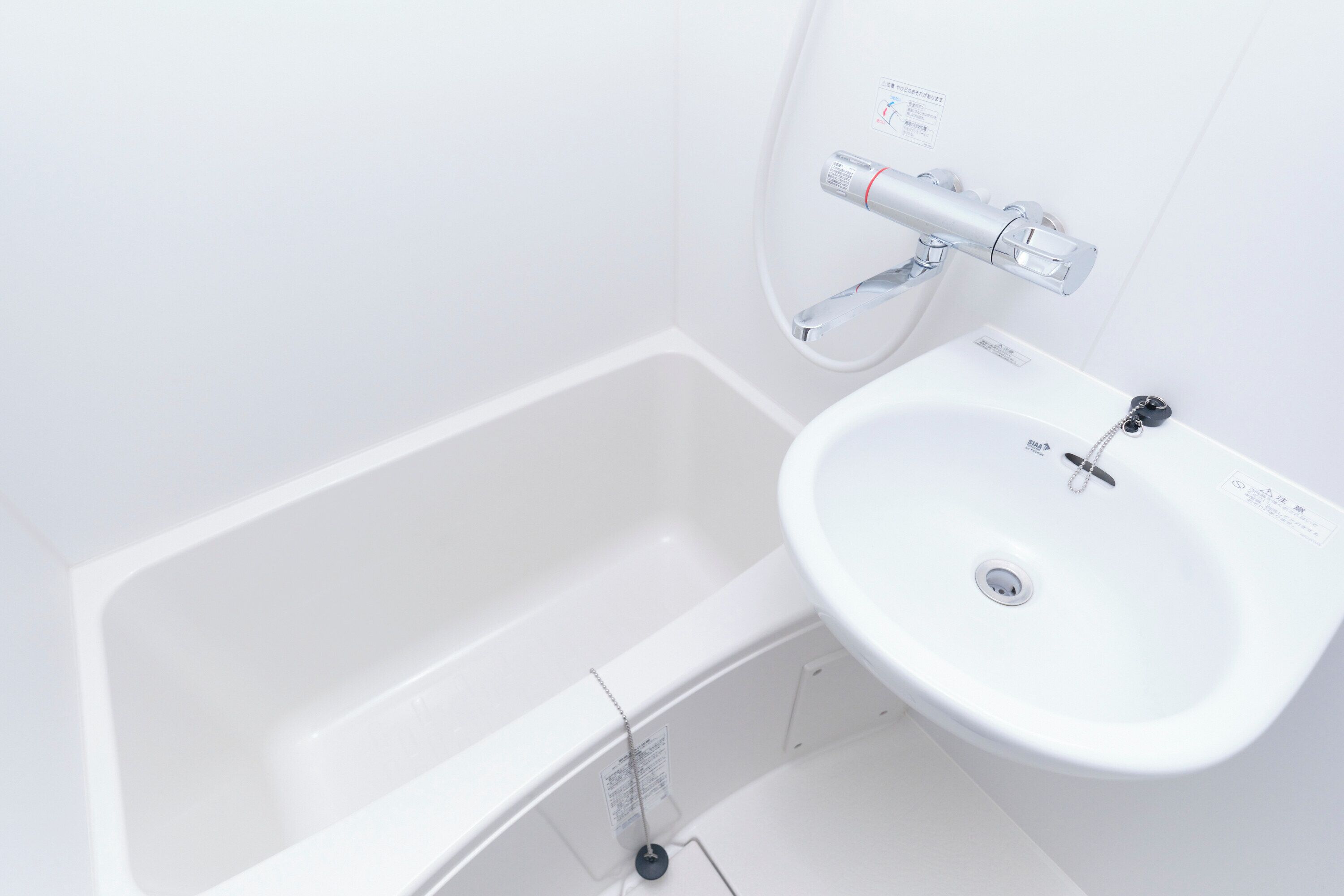 A white bathroom with a bathtub and a sink.
