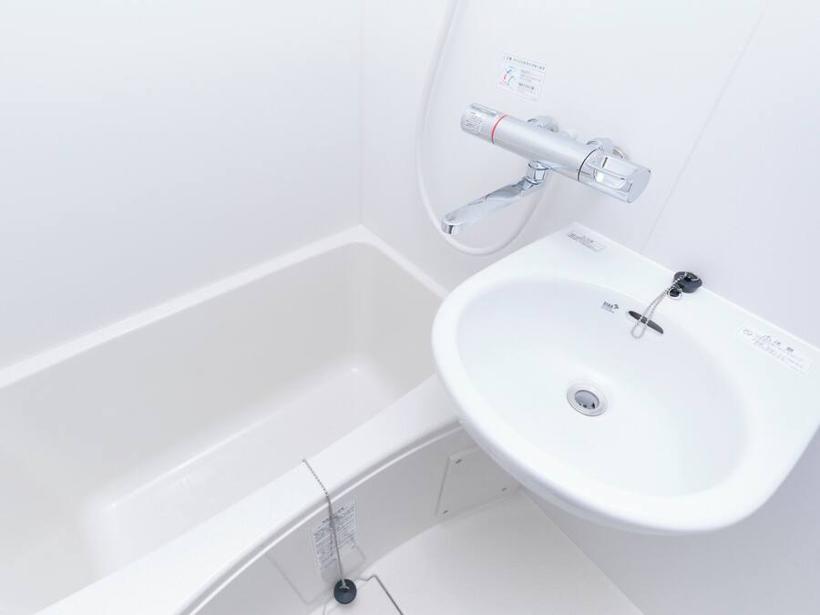 A white bathroom with a bathtub and a sink.