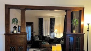 Un comedor con una mesa de madera preparada para dos personas, dos velas y un mantel azul.