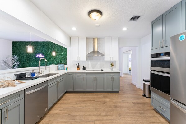Enjoy cooking in this well-lit kitchen with a central island, stainless steel range hood, and oven.