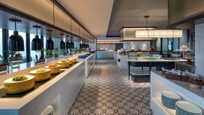 A modern kitchen with a long counter, multiple serving stations, and a patterned floor.
