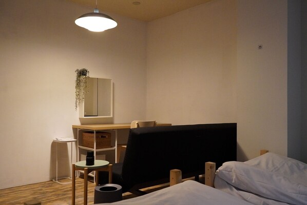 Un dormitorio pequeño y bien iluminado con una cama, un escritorio y una silla.
