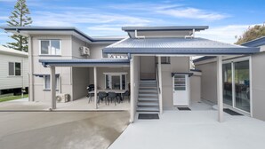 A modern two-story house with a covered patio, a staircase, and a garage. - The Castaway (Emu Park)