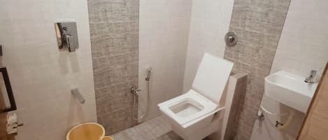 A small, modern bathroom with a toilet, sink, and shower.