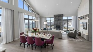 A modern living space with a dining area, a sofa set, and a fireplace. - Luxury Corner Suite, Private Hot Tub, walk to lift (Park City)