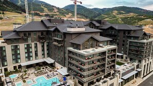 A multi-story hotel with a rooftop pool and outdoor seating areas. - Luxury Corner Suite, Private Hot Tub, walk to lift (Park City)