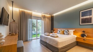 A modern hotel room with a large bed, a desk, a chair, and a view of the outdoors. - Villa Serenity- Modern villa for an exclusive vacation in Crete (Kournás)