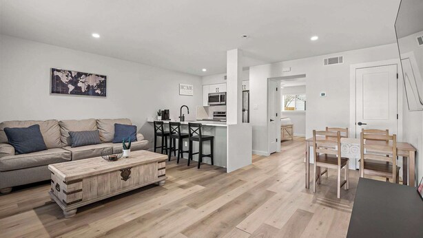 Una sala de estar moderna con un sofá, una mesa de centro y un comedor con sillas y una mesa.