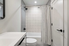 Un baño compacto con ducha, inodoro y bañera.