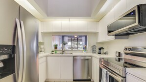 Una cocina moderna con electrodomésticos de acero inoxidable, lavavajillas y horno empotrado.
