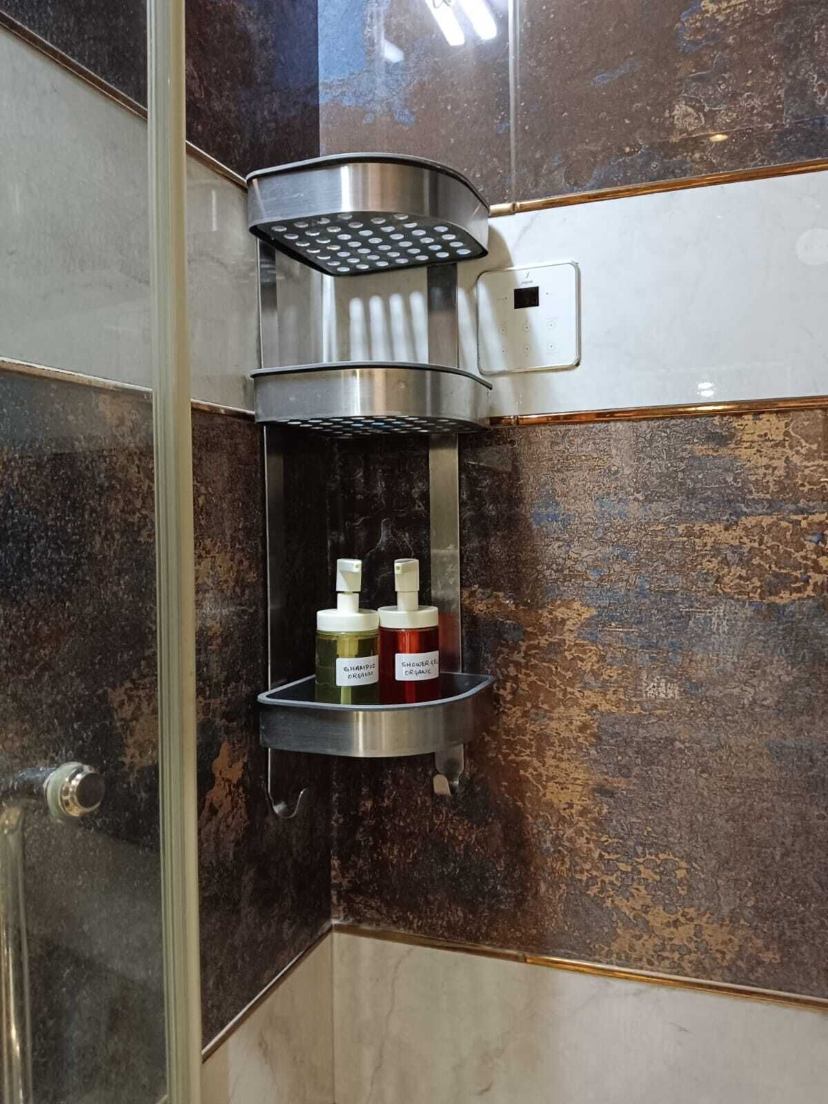 Un bagno con doccetta integrata, dispenser per sapone e flacone di shampoo.