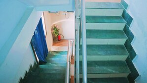 Eine Treppe mit Metallgeländer und einem blauen Vorhang oben.