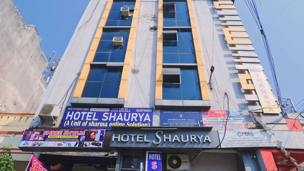 Ein Hotel namens Hotel Shaurya mit Schildern für Handy-Zubehör und Dienstleistungen im Bereich Computer-Management.