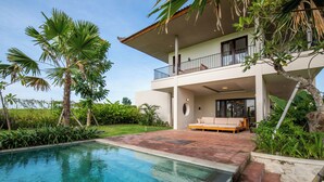 A modern house with a pool, a balcony, and lush greenery. - Atelier Home by Great Bali Villas (Selemadeg)