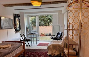 A room with a bed, a desk, a chair, a table, and a large window. - Fully equipped room in village apartment (Grasse)