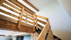 Eine Holztreppe mit modernem Design, die zu einer oberen Etage führt.