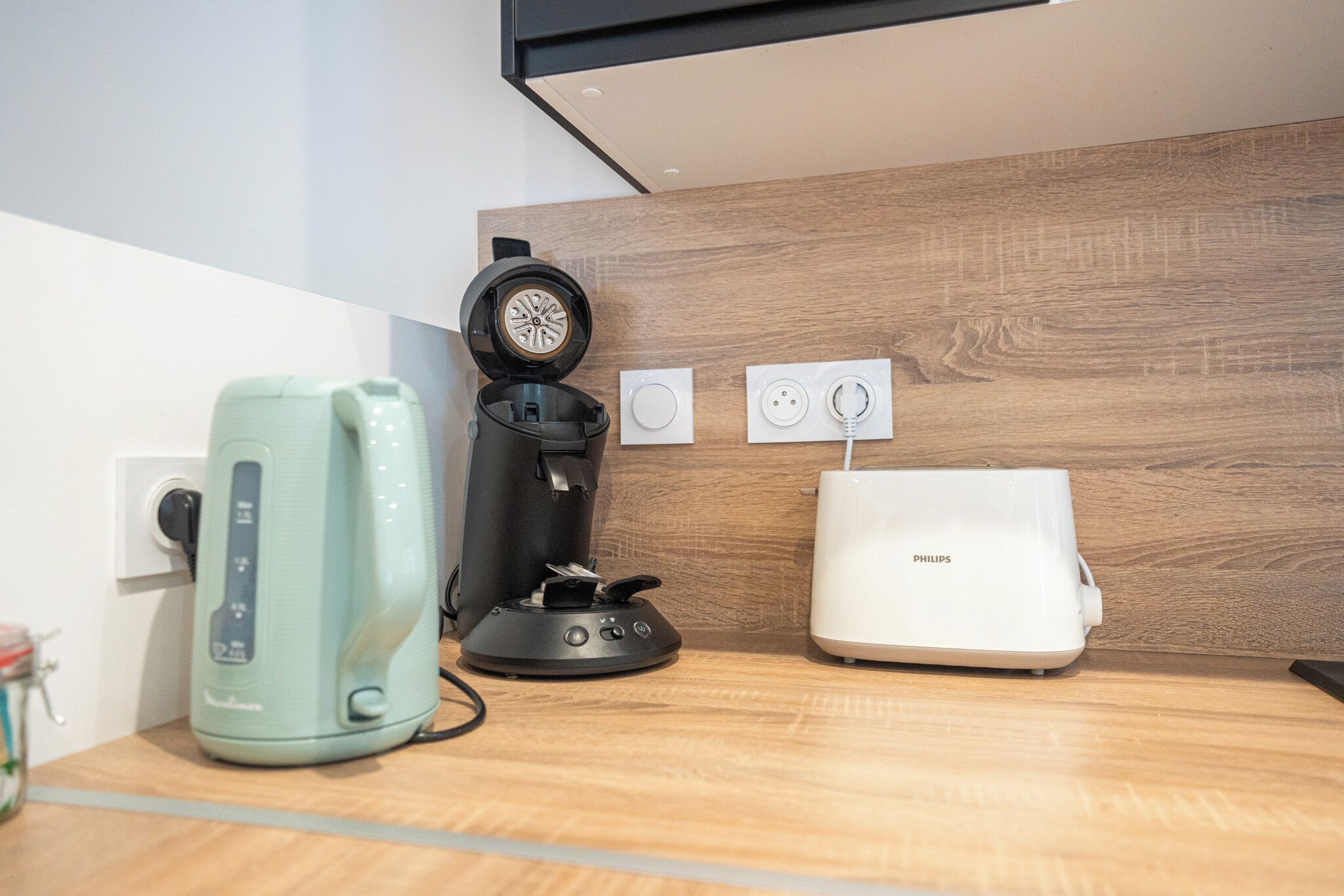Eine Küche mit Kaffeemaschine, Espressomaschine und einem Philips Toaster auf der Arbeitsfläche.
