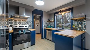 A modern kitchen with a central island, built-in oven, and a backsplash with a floral pattern. - Incredible Golfside Single Level Ranch, Open Layout w/ Vintage Charm, Huge Patio, Close 2 Everything (Gresham)