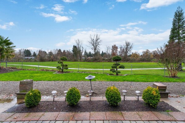 A park with a paved walkway, neatly trimmed bushes, and a clear sky. - Incredible Golfside Single Level Ranch, Open Layout w/ Vintage Charm, Huge Patio, Close 2 Everything (Gresham)