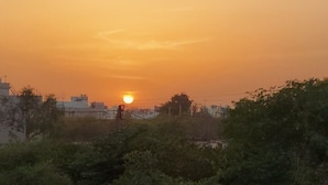 Un atardecer sobre un paisaje urbano con edificios y vegetación.