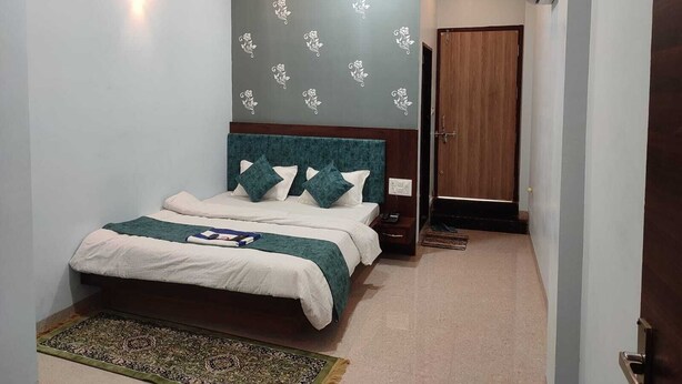 Un dormitorio con cama, mesita de noche, ventilador de techo y una puerta.