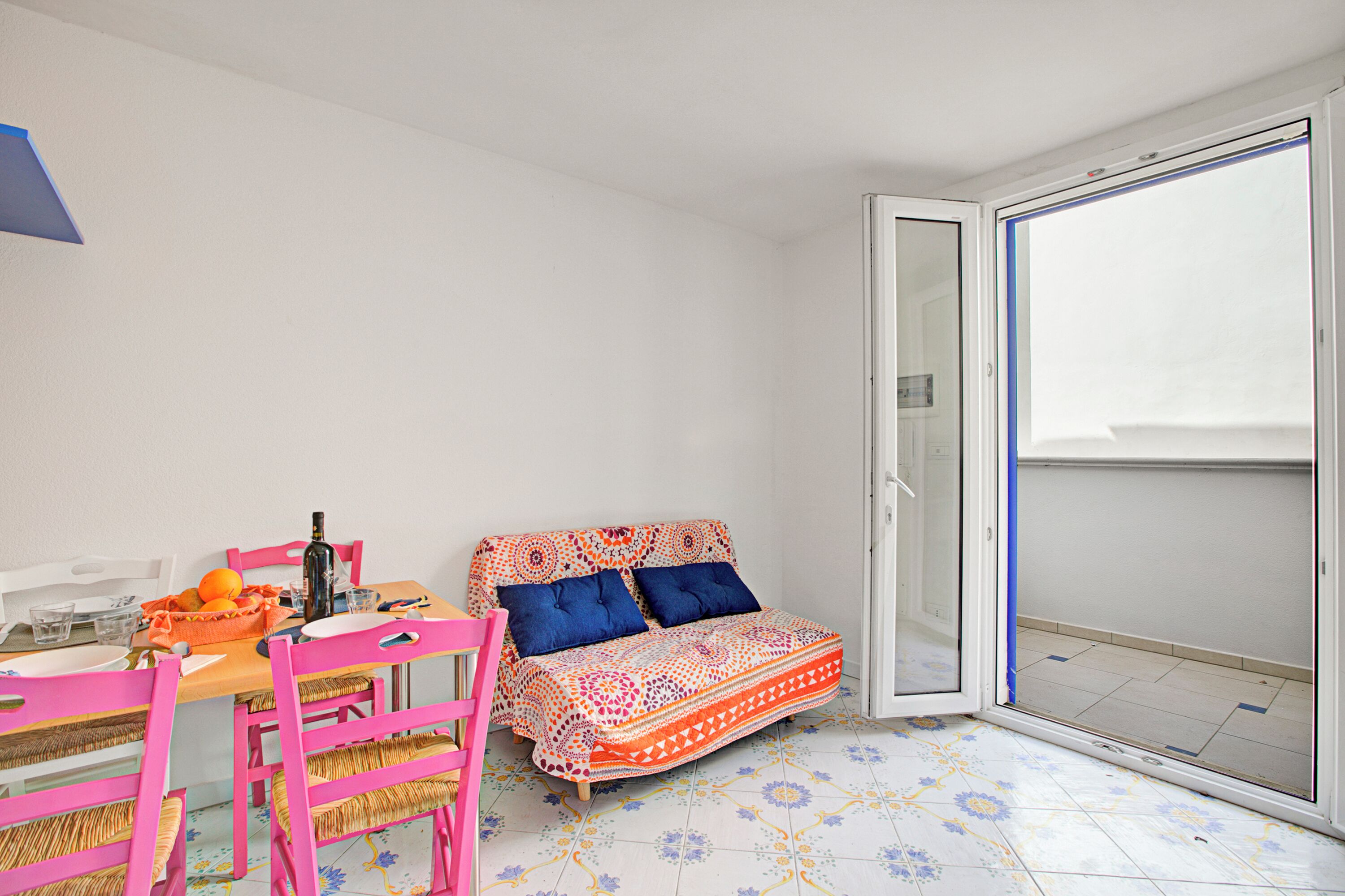 Una habitación pequeña con una cama, una mesa con sillas y una ventana.