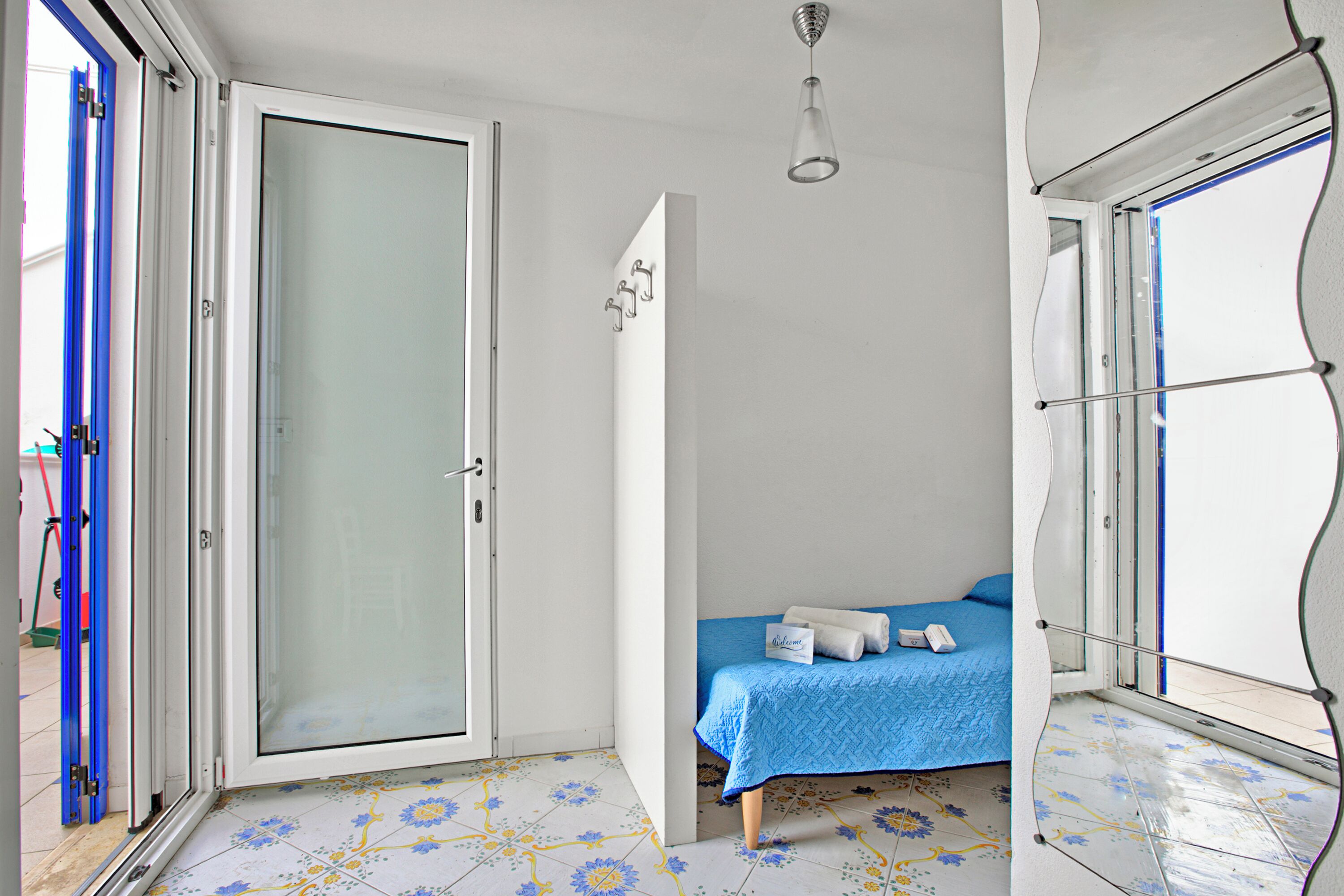 A bedroom with a bed, a nightstand, and a window.