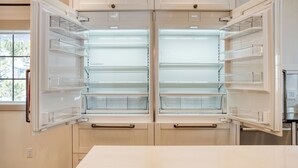 A modern kitchen with two open refrigerators, a window, and wooden cabinets. - Indoor Pool, Gym & Hot Tub Near Keystone | Crown Jewel of Keystone by AvantStay (Keystone)