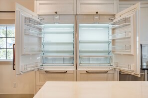 A modern kitchen with two open refrigerators, a window, and wooden cabinets. - Indoor Pool, Gym & Hot Tub Near Keystone | Crown Jewel of Keystone by AvantStay (Keystone)