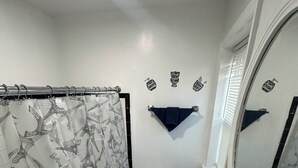 A bathroom with a shower curtain featuring a Parisian design, a toilet, a sink, and a mirror.