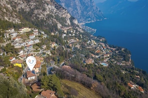 A mountainous village with houses, a lake, and a prominent yellow building. - Casa Panorama in Tremosine With View Terrace (Tremosine)