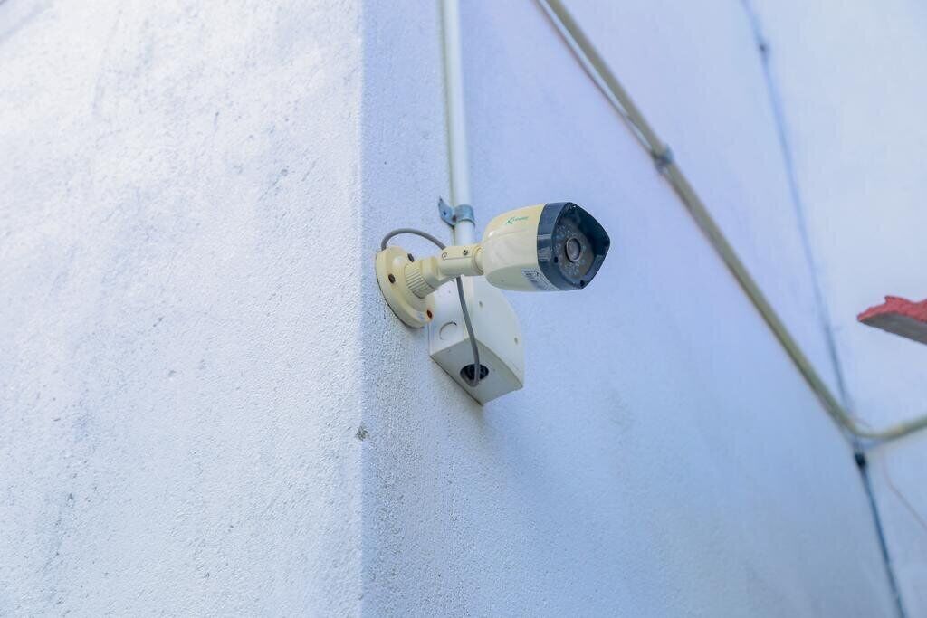 Telecamera di sicurezza montata su una parete bianca.