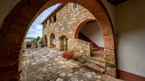 A stone courtyard with arched walkways and a rustic building. - In The Heart Of Chianti, Pool, Wifi, View (Lilliano)
